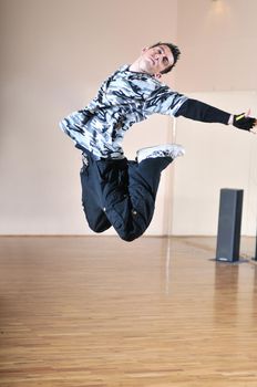 young man performing break dance in dance studio