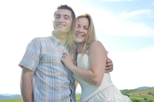 happy bride and groom walking and run on beautiful meadow outdoor at sunset 