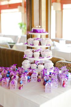 Violet decorations and sweet cute cakes for party. Concept of birthday sweets and tasty food.