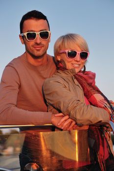 happy young couple in love  have romantic time at summer sunset   at ship boat while  representing urban and countryside fashin lifestyle