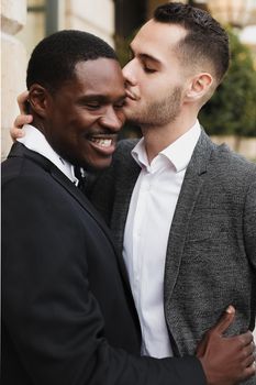 Afro american gay hugging european man outdoors. Concept of lgbt and same sex couple.