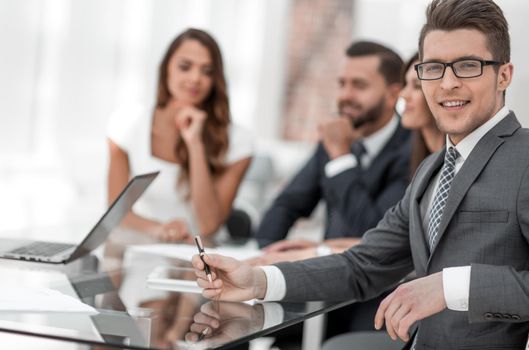 young businessman with his business team sitting at his Desk.business concept