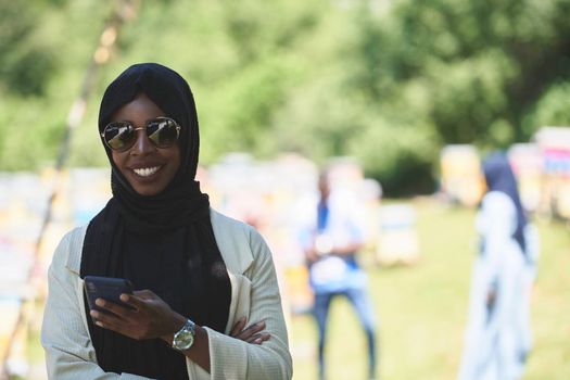 african  business woman using smart phone wearing traditional islamic clothes