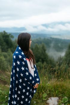 Woman standing on top of a hill, against the background of a valley in the fog