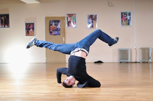 young man performing break dance in dance studio