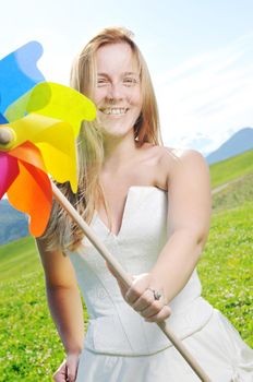 happy young beautiful bride after wedding ceremony event have fun outdoor on meadow at sunset with windmill toy and representing smart energy 