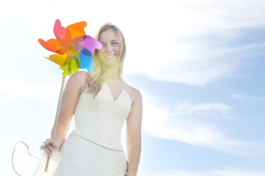 happy young beautiful bride after wedding ceremony event have fun outdoor on meadow at sunset with windmill toy and representing smart energy 