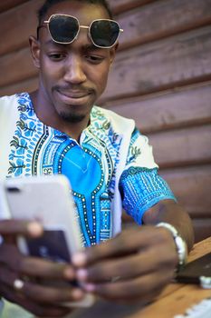 Native Sudan black african man using smart phone and wearing traditional clothes