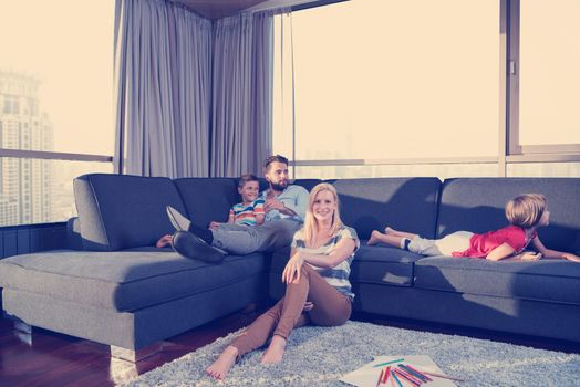 Happy Young Family Playing Together at home on the floor using a tablet and a children's drawing set