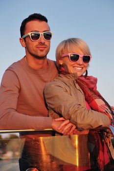 happy young couple in love  have romantic time at summer sunset   at ship boat while  representing urban and countryside fashin lifestyle