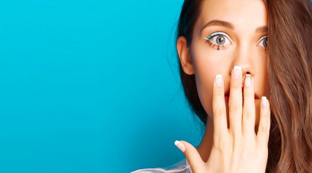 young pretty adorable brunette woman with curly hair close up like doll makeup on blue background, posing emotional, lifestyle people concept