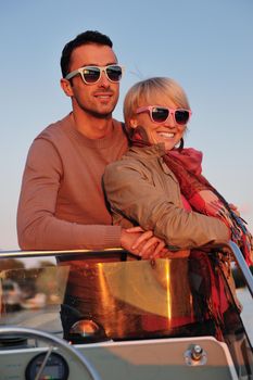 happy young couple in love  have romantic time at summer sunset   at ship boat while  representing urban and countryside fashin lifestyle