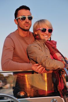 happy young couple in love  have romantic time at summer sunset   at ship boat while  representing urban and countryside fashin lifestyle