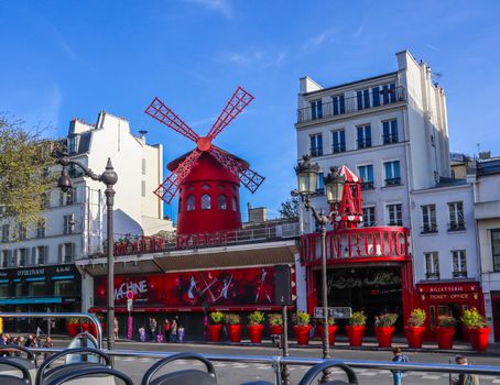 Paris / France - April 06 2019: Moulin Rouge is a famous cabaret in Paris France. View from the tourist bus