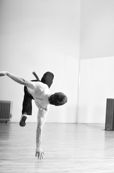 young man performing break dance in dance studio