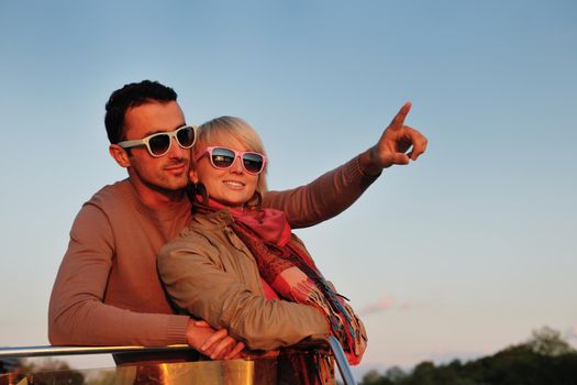 happy young couple in love  have romantic time at summer sunset   at ship boat while  representing urban and countryside fashin lifestyle