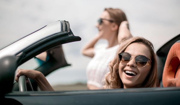 close up.two girlfriends traveling in a convertible car . fashionable lifestyle