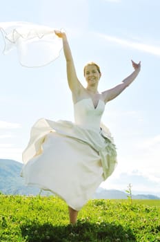 happy young beautiful bride after wedding ceremony event have fun outdoor on meadow at sunset