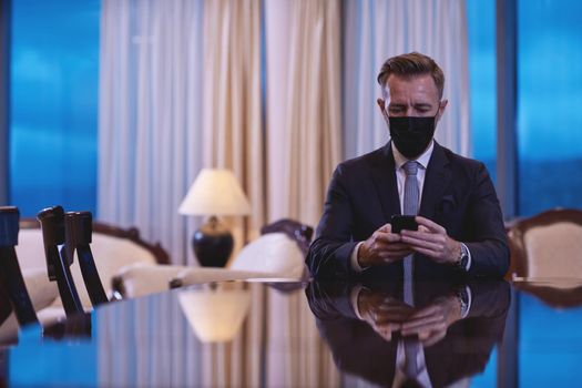 corporate business man wearing face mask and  using smart phone at luxury office