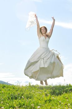 happy young beautiful bride after wedding ceremony event have fun outdoor on meadow at sunset