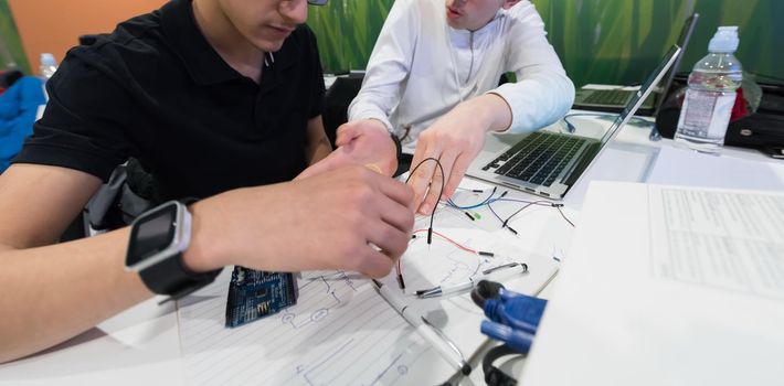 it students in computer science classroom  working together on project with mini pc hardware and code programming software on laptop