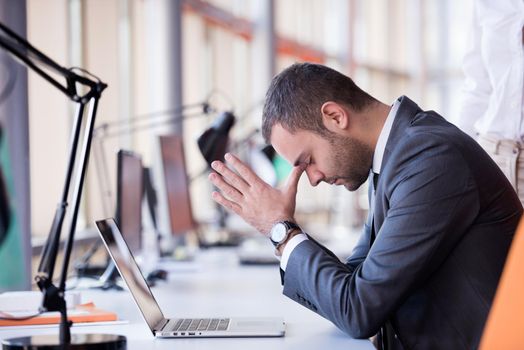 frustrated young business man working on laptop computer at office