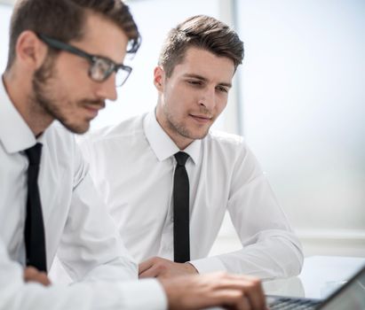 young businessmen looking at a laptop on the table in the office