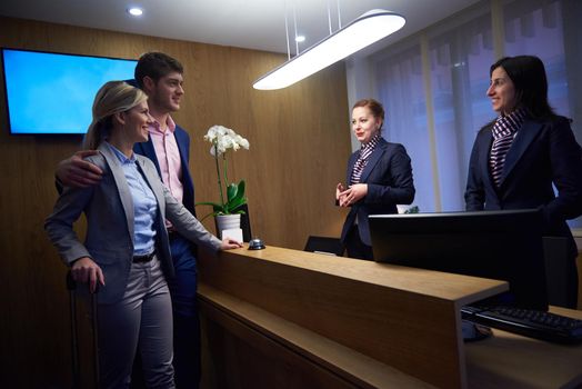 Couple on a business trip doing check-in at the hotel