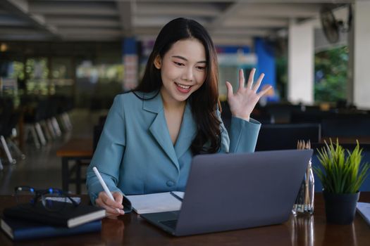 Asian business woman using laptop talk to colleagues for briefing business plan in video call. finance fund investment concept.