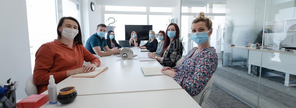 real businesspeople on business meeting in bright office on coronavirus new normal time wearing protective medical face mask and keep distance