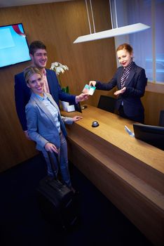 Couple on a business trip doing check-in at the hotel