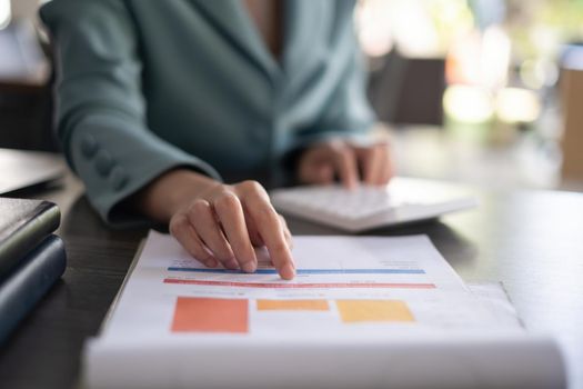 A businesswoman's hand points to the company's budget chart for audit account.