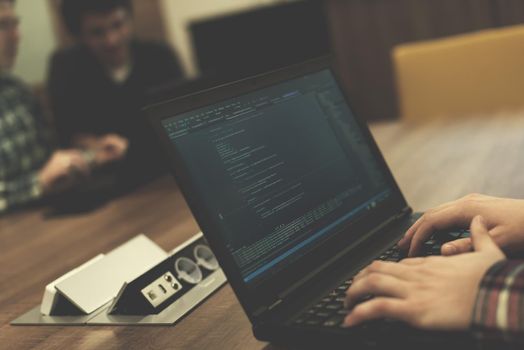 software developer writing programming code on laptop computer