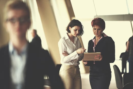 Smilling young business woman in front her team blured in background. Group of young business people. Modern bright  startup office interior.