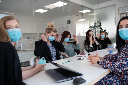 real businesspeople on business meeting in bright office on coronavirus new normal time wearing protective medical face mask and keep distance