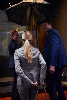 Young business people couple entering city  hotel, looking for room, holding suitcases while walking on street