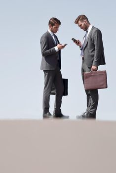 business colleagues with mobile phones standing on the street.photo with copy space