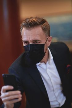 corporate business man wearing face mask and  using smart phone at luxury office
