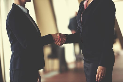 two corporate business woman at modern bright office interior make deal and handshake