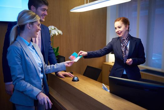 Couple on a business trip doing check-in at the hotel