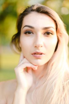 Closeup portrait of young beautiful girl, green background. Concept of beauty and everyday makeup.