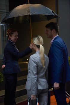 Young business people couple entering city  hotel, looking for room, holding suitcases while walking on street