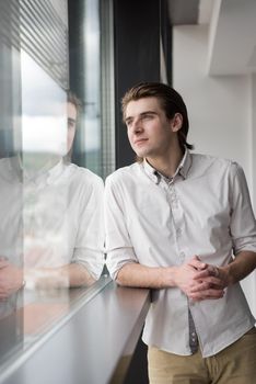 portrait of young businessman at startup office by the window