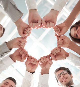 bottom view. business team standing in a circle.the concept of victory.