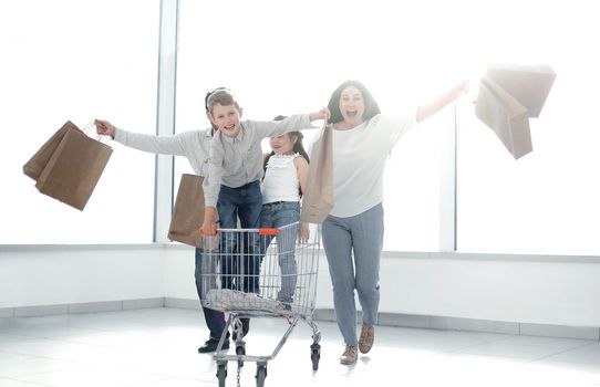 Full length portrait of a young family standing with shopping cart.photo with copy space