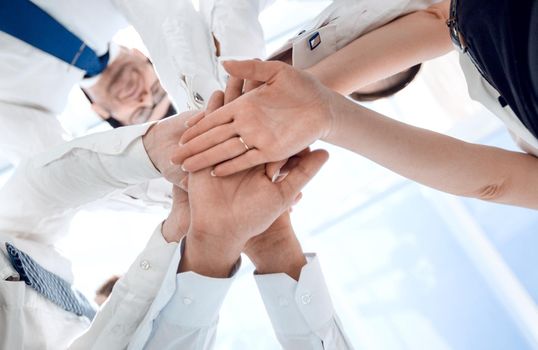 close up.large business team is forming a circle and his hands clasped together