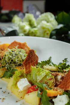 Summer diet salad with leaves of lettuce, watermelon, peach and feta cheese. On a light blue background copy space.