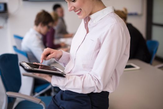 young hispanic businesswoman portrait with  tablet computer at modern startup business office interior, people group on team meeting blured in background