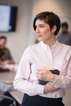 young hispanic businesswoman portrait with  tablet computer at modern startup business office interior, people group on team meeting blured in background