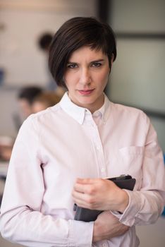 young hispanic businesswoman portrait with  tablet computer at modern startup business office interior, people group on team meeting blured in background